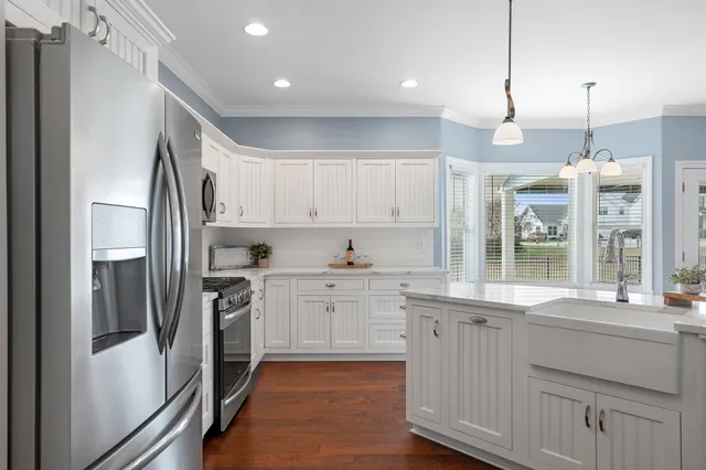 a kitchen with white cabinets and stainless steel appliances