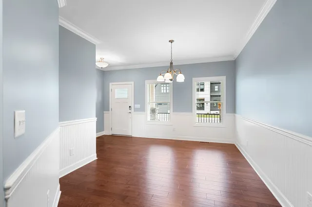 a view of a room with wooden floors and chandelier