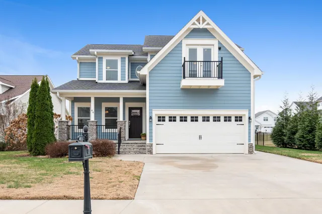 a view of a house with a yard and potted plants