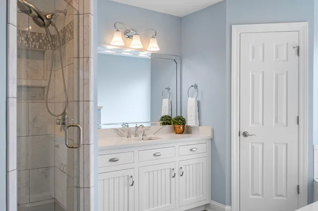 a bathroom with a sink vanity granite and shower