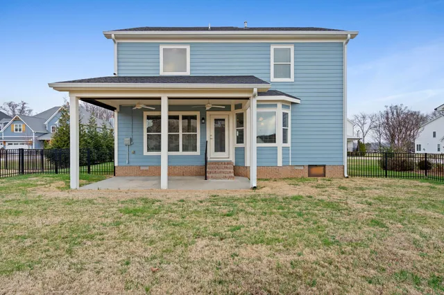 a view of a house with backyard and a large tree