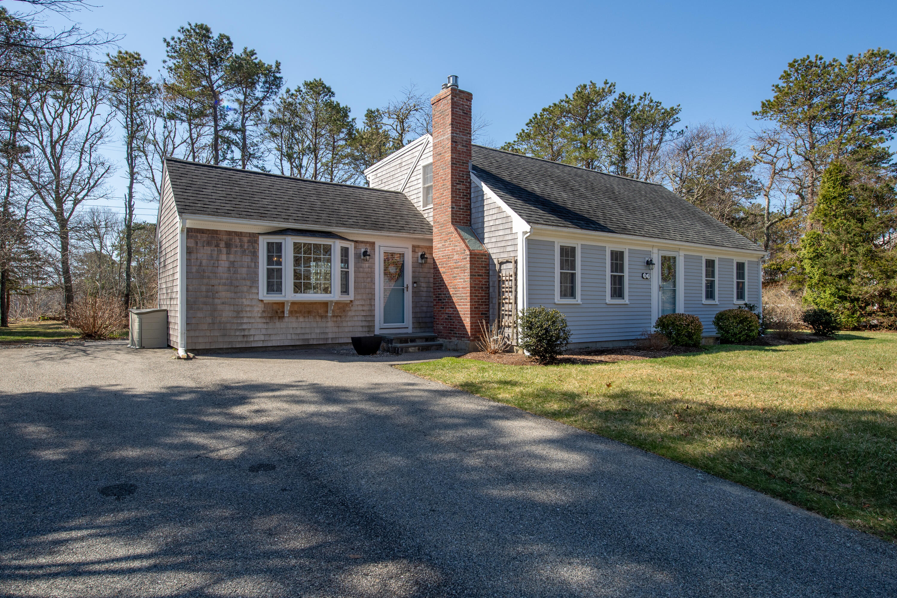 89 Trout Brook Road Cotuit, MA 02635 - Photo 43 of 67 a front view of a house with a garden and yard