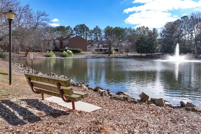 a view of a lake with a bench and trees