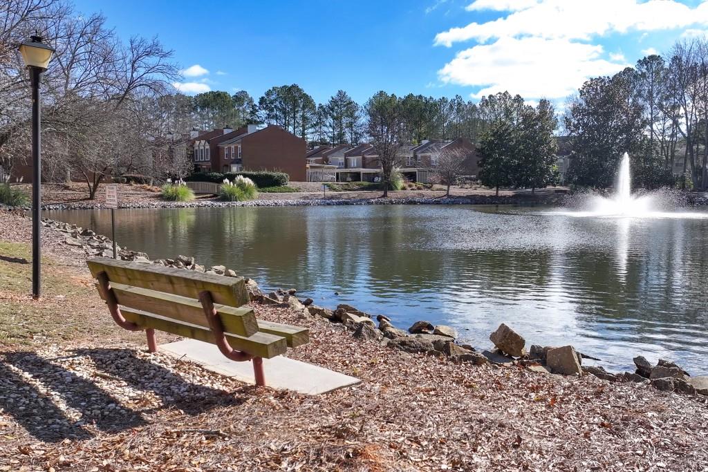 4138 Crape Myrtle Lane Duluth, GA 30096 - Photo 9 of 50 a view of a lake with a bench and trees