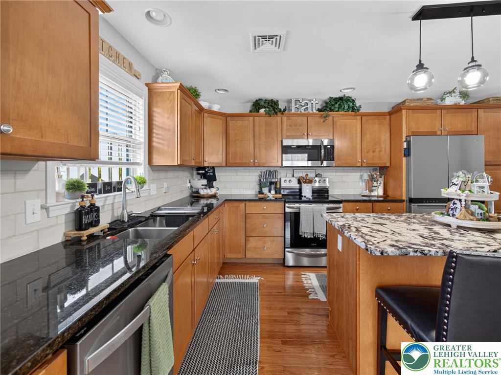 4148 Ross Road Bethlehem, PA 18020 - Photo 35 of 67 A warm and inviting kitchen showcases rich wood cabinetry, granite countertops, and modern stainless steel appliances.