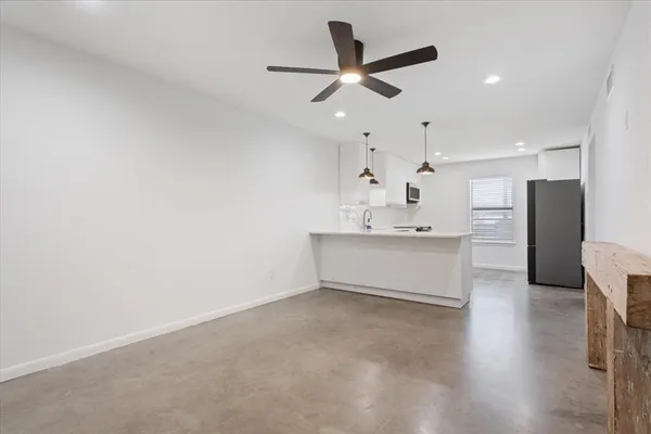 a room with kitchen island a sink and wooden floor