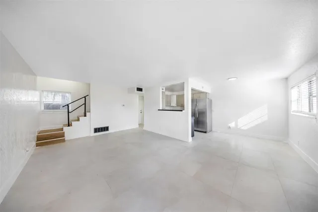 an empty room with entrance and windows