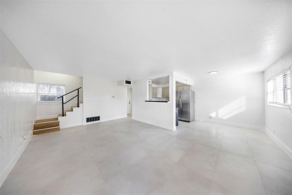 an empty room with entrance and windows