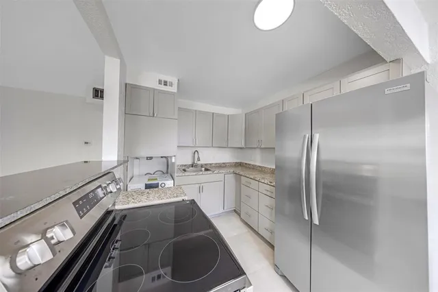 a kitchen with a sink appliances and cabinets