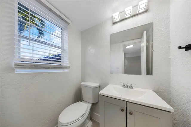 a bathroom with a toilet a sink and mirror