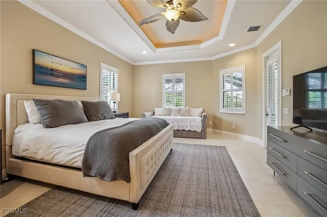 a bedroom with a large bed a flat tv screen and dresser