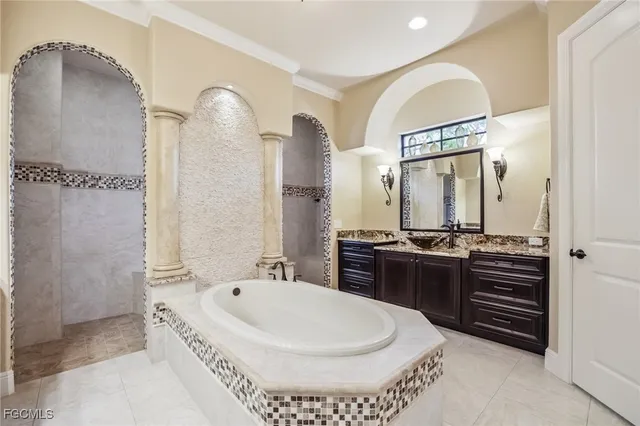 a large bathroom with a tub a double vanity sink and mirror