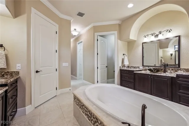 a large bathroom with a tub sink and mirror