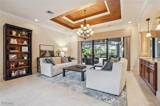 a living room with furniture a chandelier and a large window