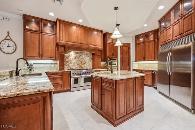 a kitchen with stainless steel appliances granite countertop a stove a sink dishwasher and a refrigerator