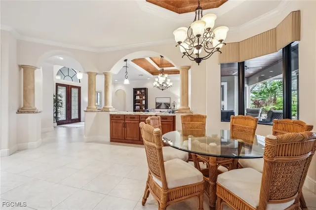 a dining room with furniture a chandelier and window