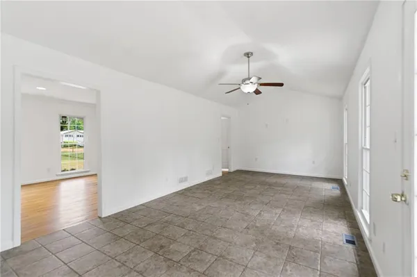 an empty room and chandelier fan