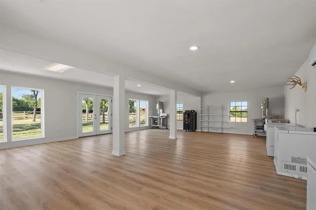 a view of an empty room with window and wooden floor