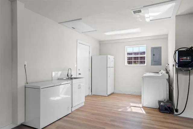 a view of a kitchen with refrigerator and wooden floor