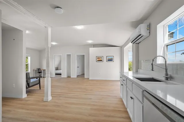 a large kitchen with a sink and wooden floor