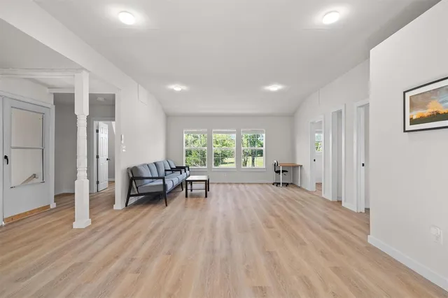 a view of empty room with wooden floor and furniture