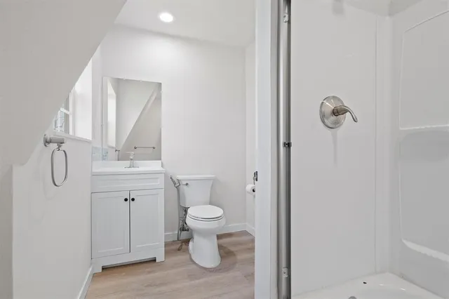 a bathroom with a granite countertop toilet a sink and a mirror