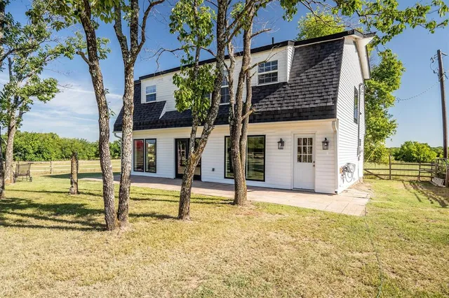 a view of a house with backyard and a tree