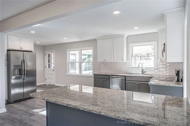 a kitchen with stainless steel appliances granite countertop a sink stove and refrigerator
