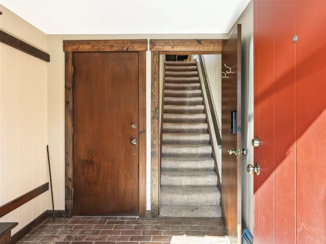 a view of a hallway with wooden floor and stairs