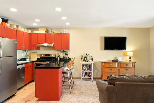 a kitchen with stainless steel appliances a stove a sink a microwave a refrigerator and cabinets