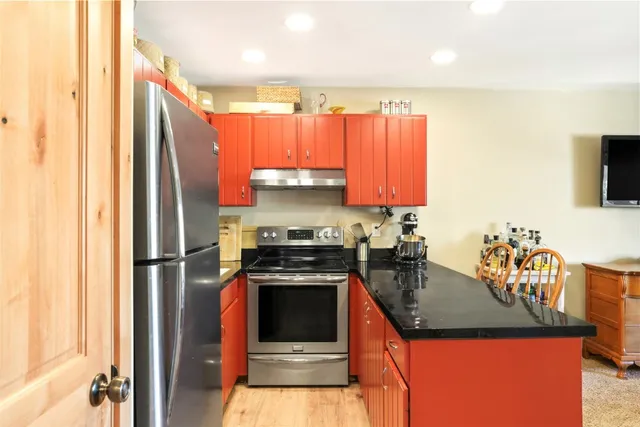 a kitchen with stainless steel appliances granite countertop a refrigerator a stove top oven a sink and dishwasher
