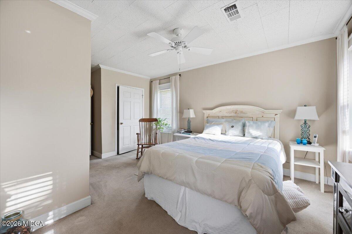214 Howard Roberts Road Gray, GA 31032 - Photo 15 of 36 a bedroom with a bed and a chandelier