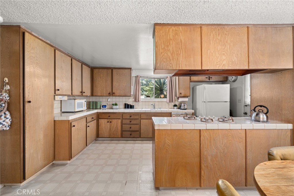 19514 Enslow Drive Carson, CA 90746 - Photo 31 of 51 a kitchen with kitchen island granite countertop a sink cabinets and window