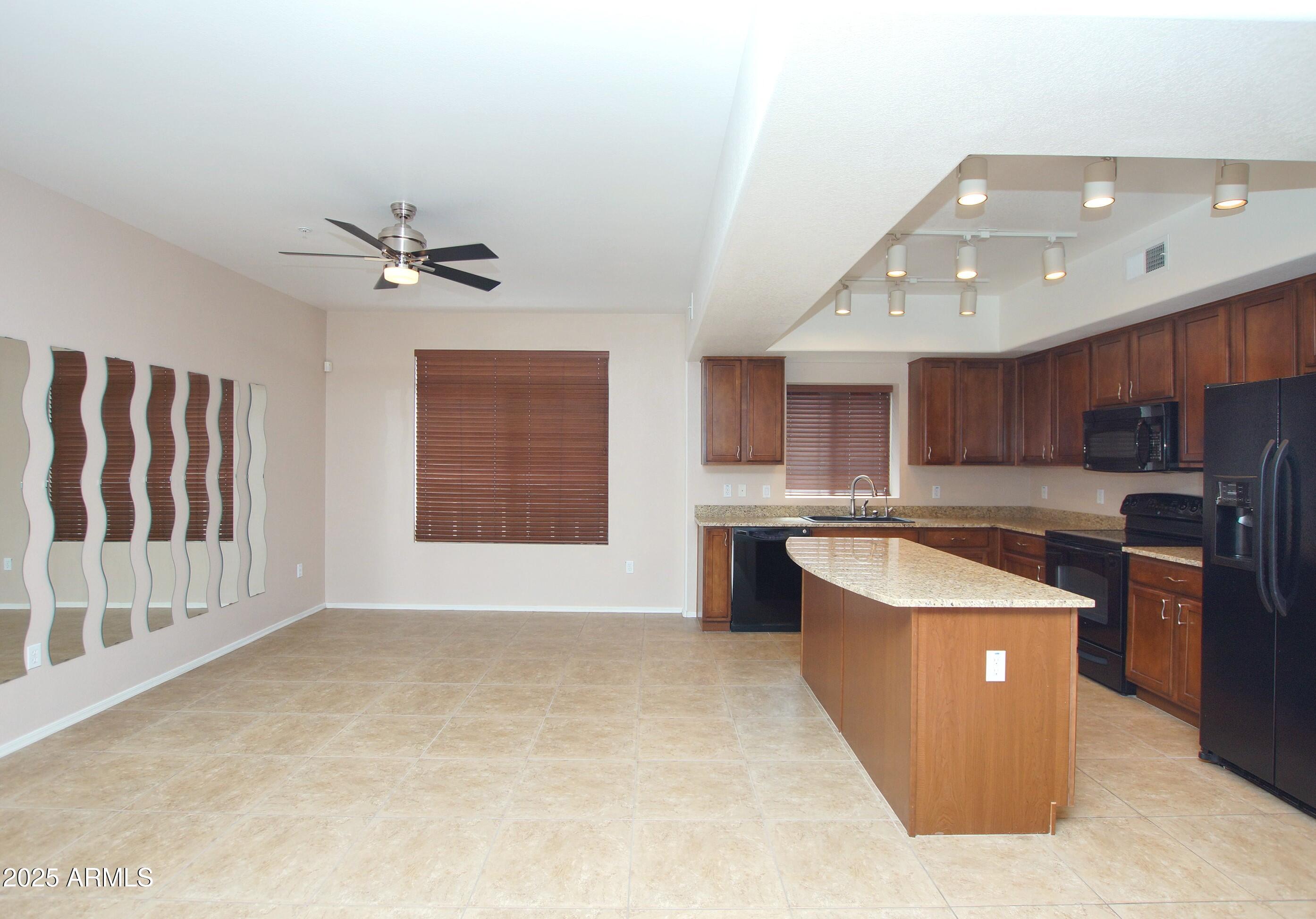 2150 West Alameda Road, Unit 1398 Phoenix, AZ 85085 - Photo 13 of 29 a large kitchen with stainless steel appliances kitchen island granite countertop a sink and a stove