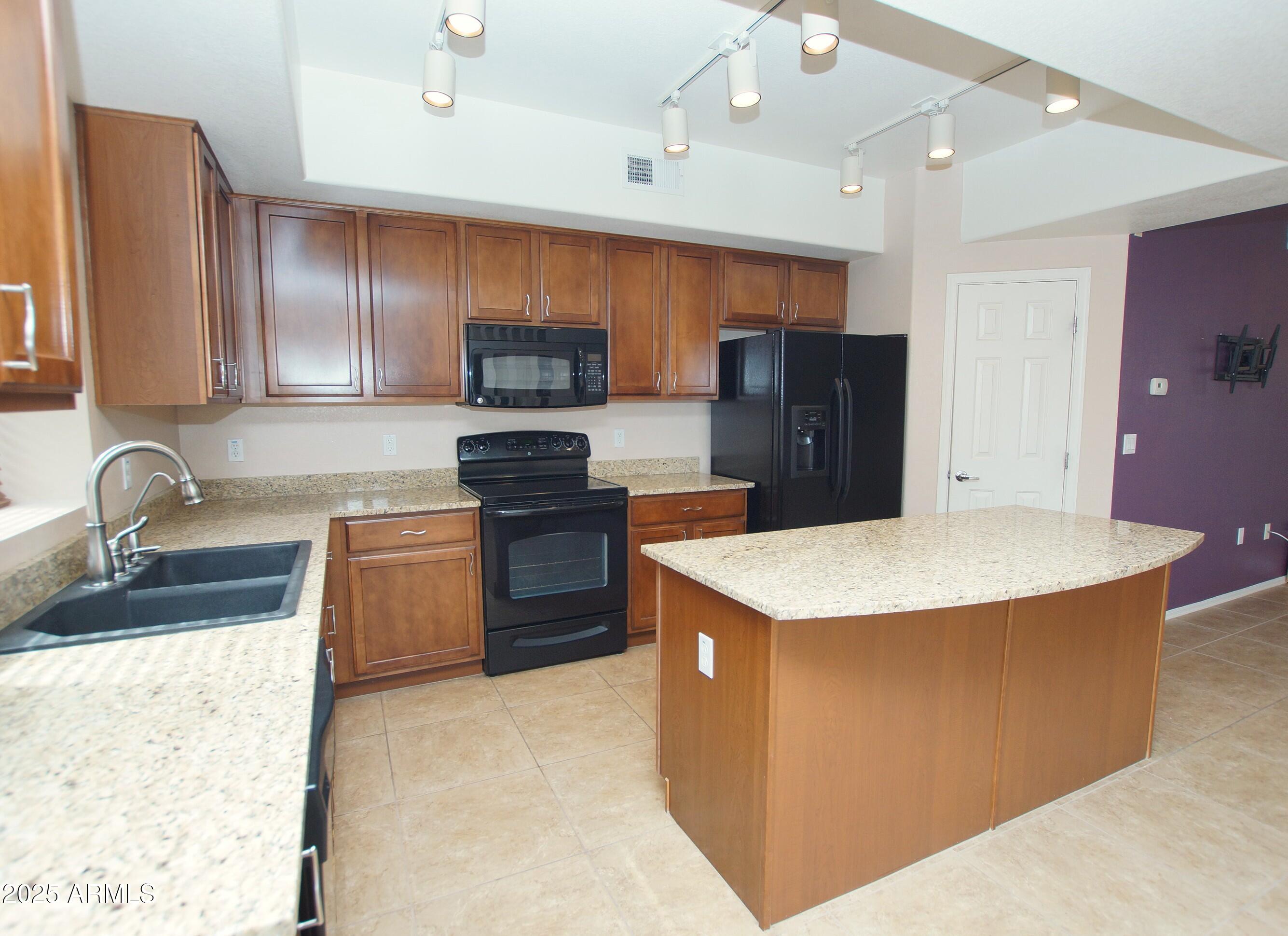 2150 West Alameda Road, Unit 1398 Phoenix, AZ 85085 - Photo 8 of 29 a kitchen with stainless steel appliances granite countertop a sink stove and refrigerator