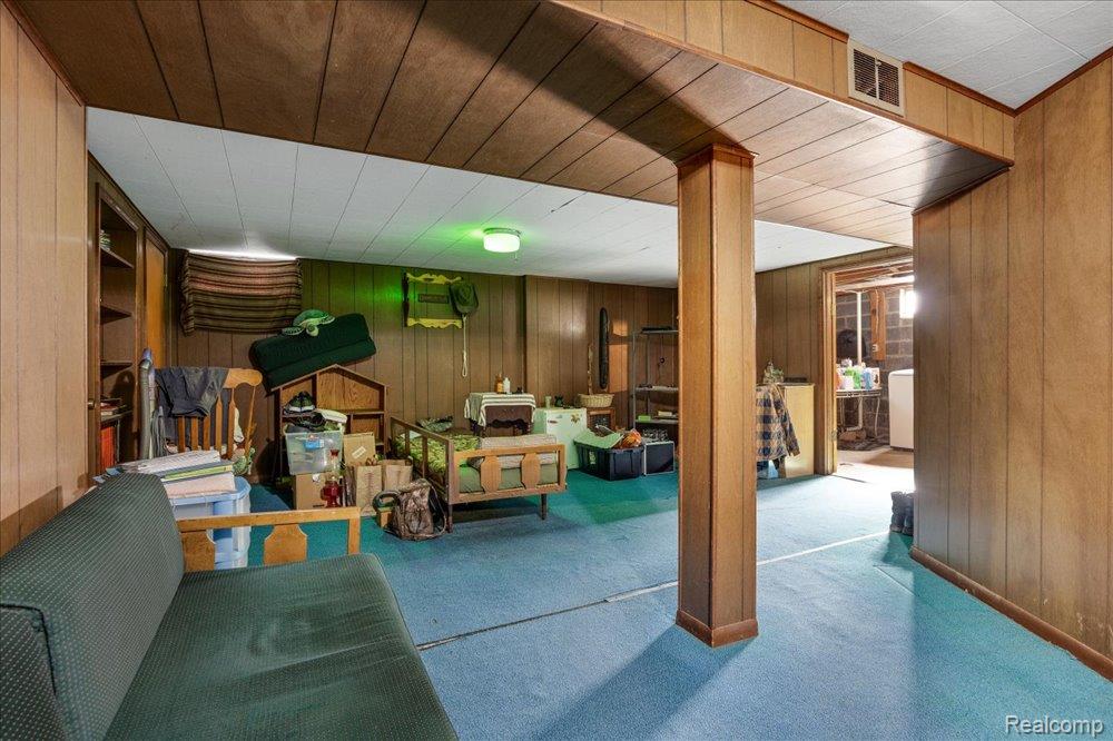 59380 10 Mile Road South Lyon, MI 48178 - Photo 30 of 53 Carpeted flooring, wood-paneled walls, built-in shelving, and exposed structural support beams