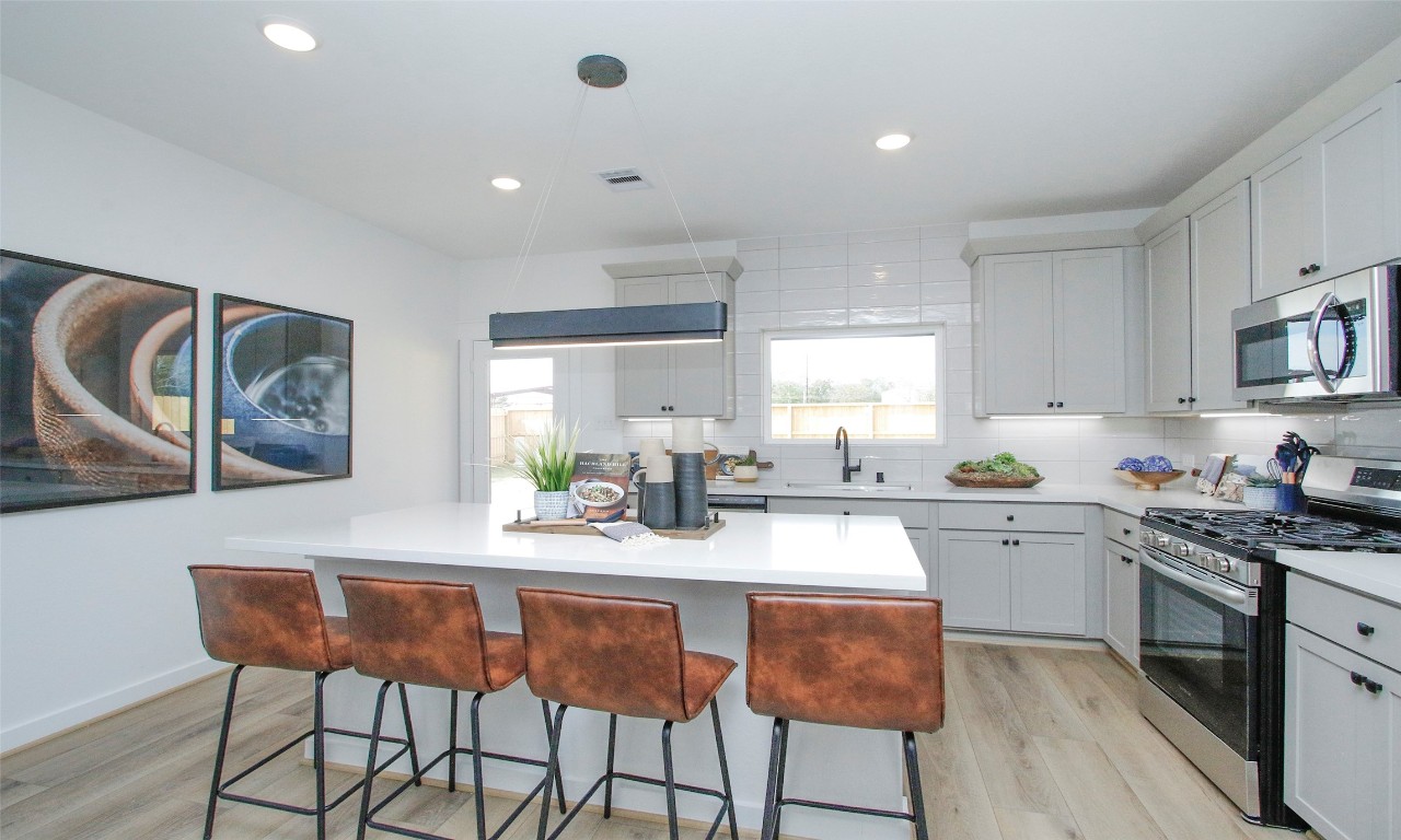 4028 Colony Riv Rock Boulevard Pinehurst, TX 77362 - Photo 5 of 21 a kitchen with stainless steel appliances granite countertop a table chairs sink and cabinets