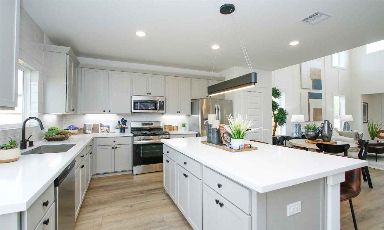 4028 Colony Riv Rock Boulevard Pinehurst, TX 77362 - Photo 6 of 21 a kitchen with stainless steel appliances kitchen island granite countertop a sink a stove and a refrigerator