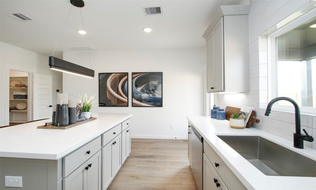 4028 Colony Riv Rock Boulevard Pinehurst, TX 77362 - Photo 7 of 21 a kitchen with stainless steel appliances a sink dishwasher and white cabinets with wooden floor