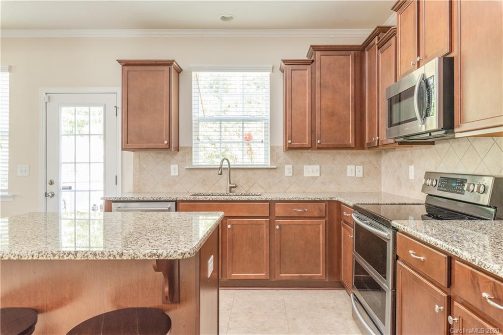 78094 Rillstone Drive Lancaster, SC 29720 - Photo 11 of 26 a kitchen with stainless steel appliances granite countertop wooden cabinets a sink and a stove