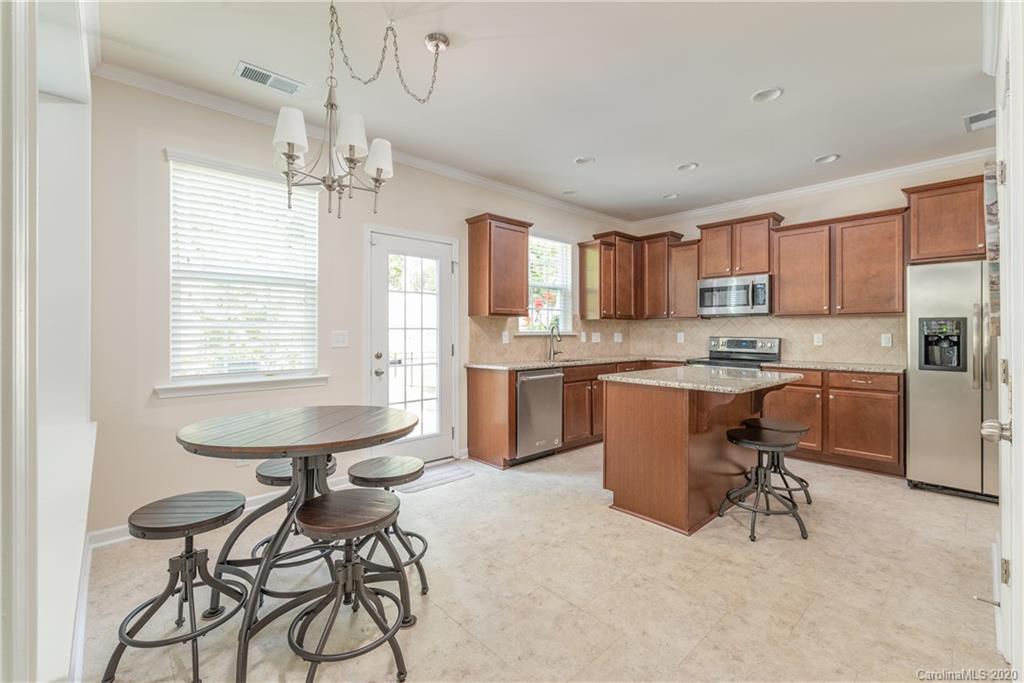 78094 Rillstone Drive Lancaster, SC 29720 - Photo 9 of 26 a kitchen with kitchen island a sink counter and chairs
