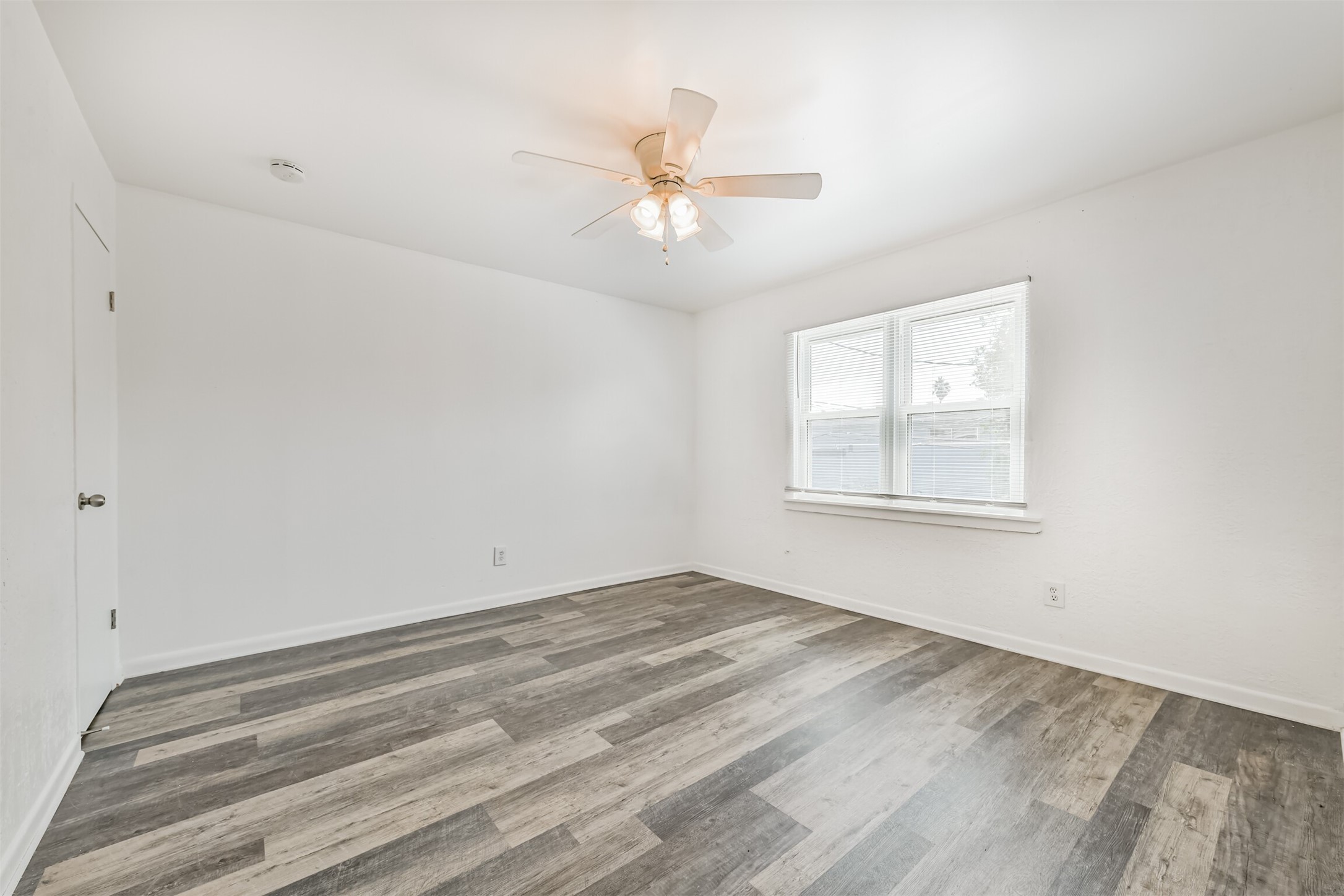 123 Strand Street, Unit REAR Galveston, TX 77550 - Photo 16 of 24 wooden floor in an empty room with a window