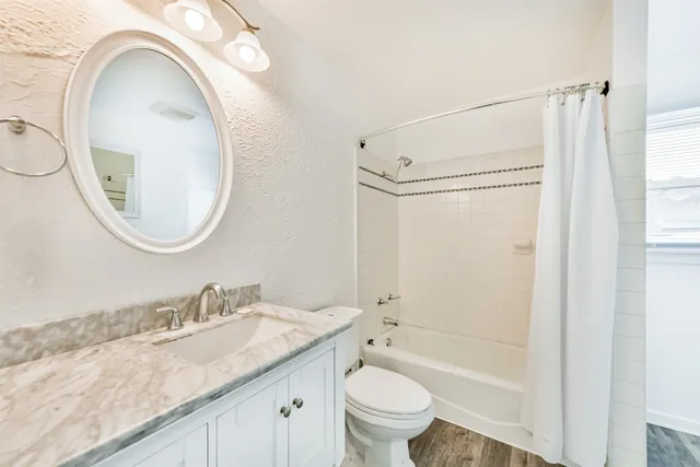 a bathroom with a granite countertop sink a toilet and a mirror