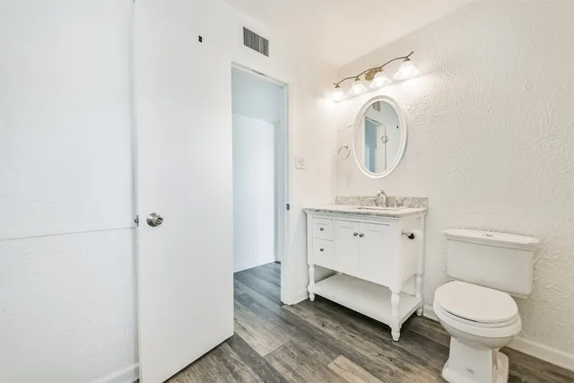 a spacious bathroom with a toilet sink and mirror