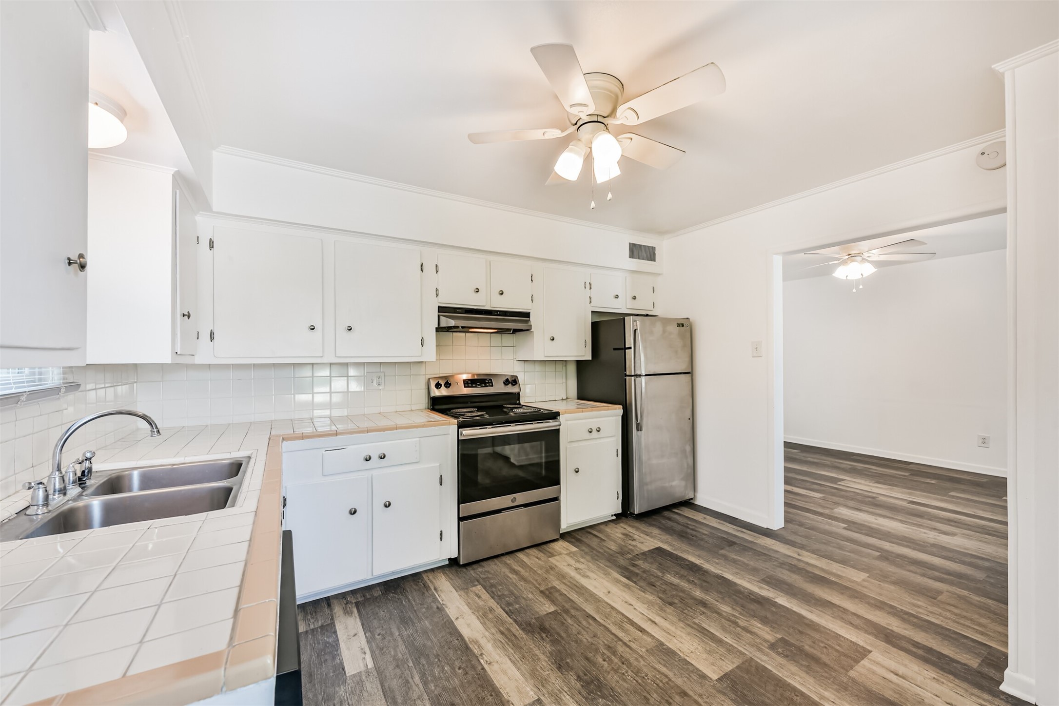 123 Strand Street, Unit REAR Galveston, TX 77550 - Photo 9 of 24 a kitchen with stainless steel appliances a sink cabinets and wooden floor