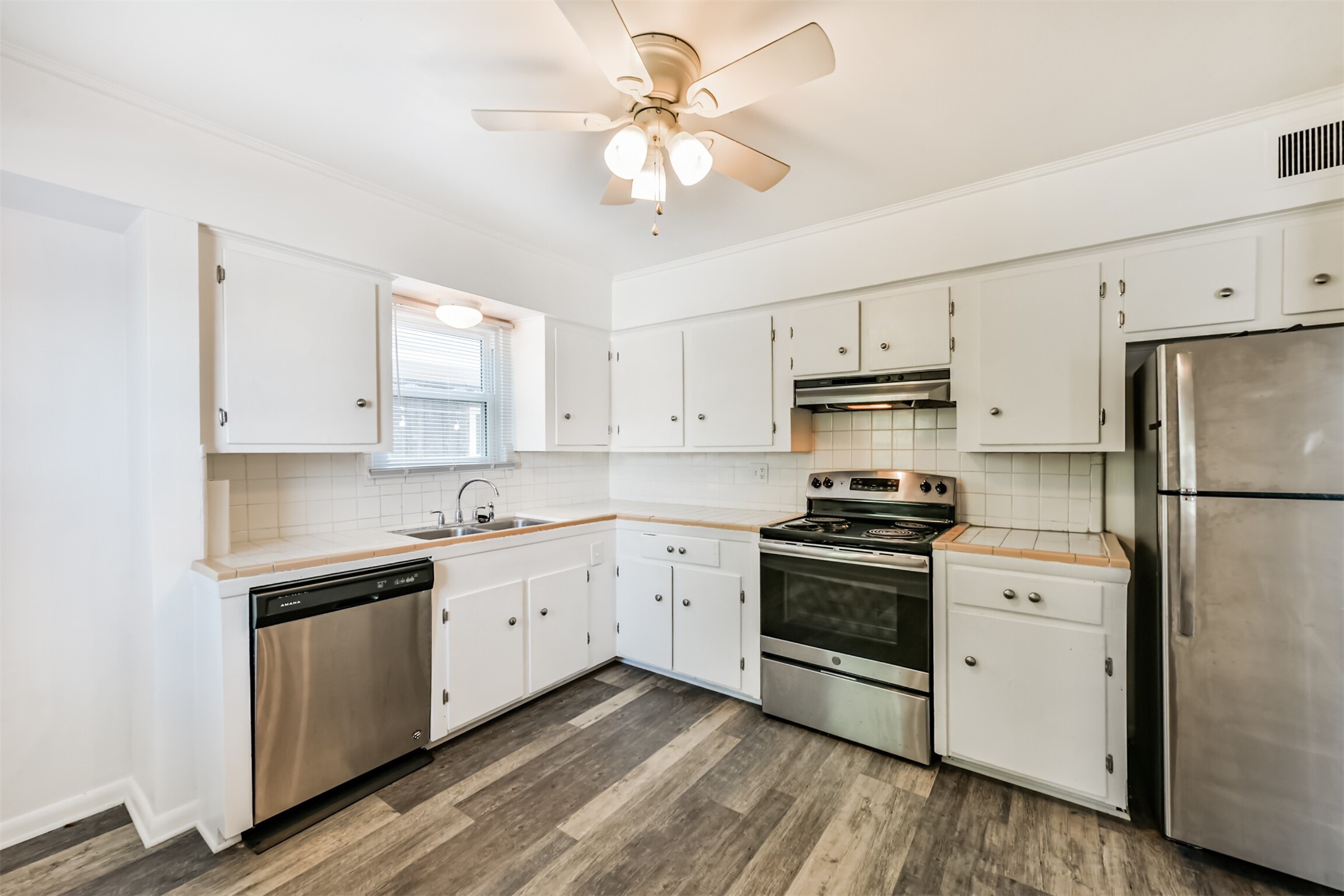 123 Strand Street, Unit REAR Galveston, TX 77550 - Photo 10 of 24 a kitchen with stainless steel appliances white cabinets and a sink
