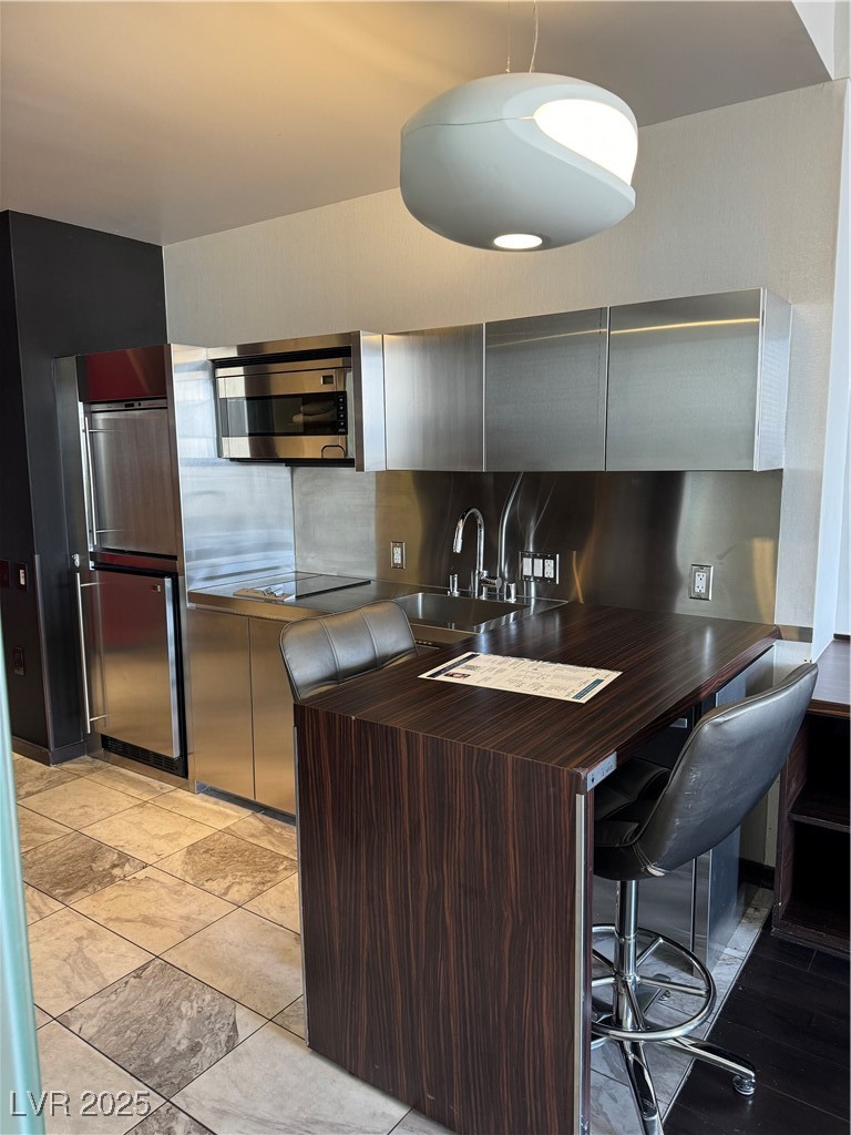 Kitchen featuring backsplash and refrigerator