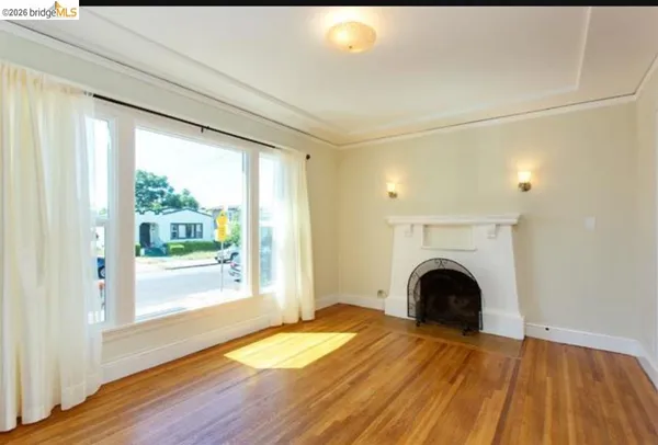 a view of empty room with wooden floor and fireplace