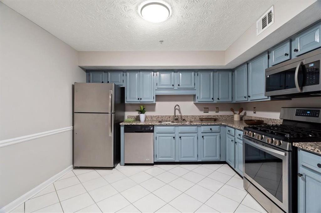 1411 Oakridge Circle Decatur, GA 30033 - Photo 11 of 26 a kitchen with granite countertop cabinets and steel stainless steel appliances