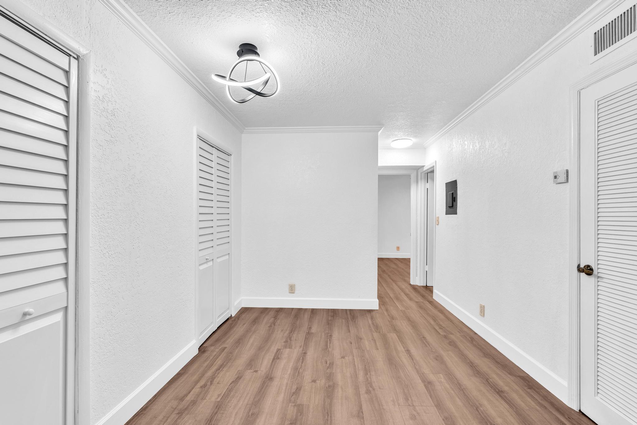 1291 Northwest 13th Street, Unit 445D Boca Raton, FL 33486 - Photo 27 of 50 a view of a room with wooden floor and white walls